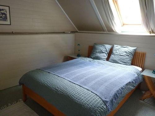 un lit dans une chambre avec une fenêtre dans l'établissement Sunshine Cottage, à Berjou