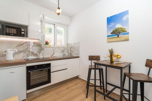 ドゥブロヴニクにあるApartment Milanelloのキッチン(カウンター、テーブル、スツール付)