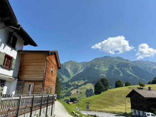 a house on a hill with mountains in the background at California House in Klosters