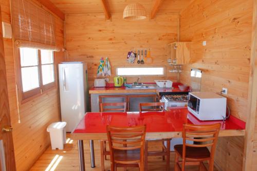 y cocina con mesa, sillas y nevera. en Punta de Choros Lodge, en Punta de Choros