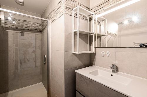 une salle de bain avec un lavabo et une douche dans l'établissement A Nepita - 150m de la plage, à Pietrosella