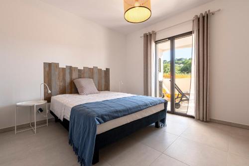 une chambre avec un lit et une porte coulissante en verre dans l'établissement A Nepita - 150m de la plage, à Pietrosella