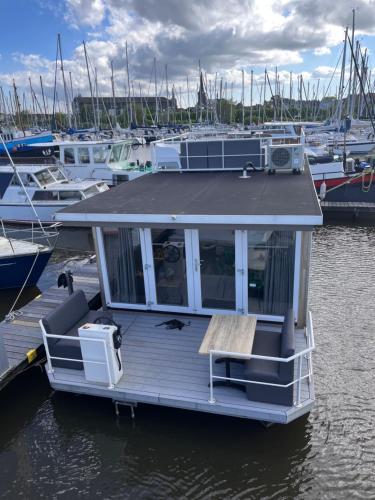 a small boat is docked at a marina at Houseboat Maatrollie NS002 in Monnickendam