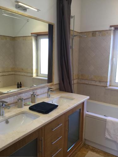 a bathroom with a sink and a mirror and a tub at Casa da Colina in Loulé