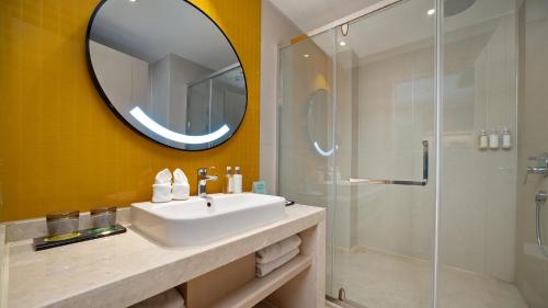 a bathroom with a sink and a mirror and a shower at Holiday Inn Dujiangyan Ancient Town by IHG in Dujiangyan