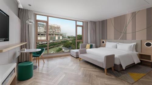 a hotel room with a bed and a large window at Holiday Inn Dujiangyan Ancient Town by IHG in Dujiangyan