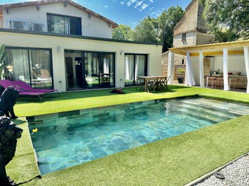 une cour arrière avec une piscine et une maison dans l'établissement Chambre dans villa de standing, à Montaigut-sur-Save