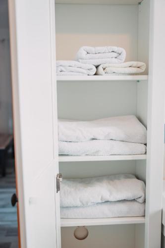 a closet filled with white towels on shelves at Bungalow Donaublick mit Pool und Garten in Sankt Nikola an der Donau