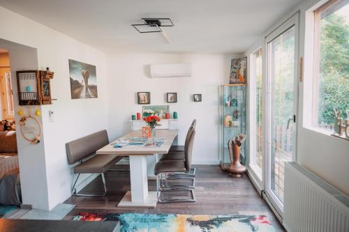 a dining room with a white table and chairs at Bungalow Donaublick mit Pool und Garten in Sankt Nikola an der Donau