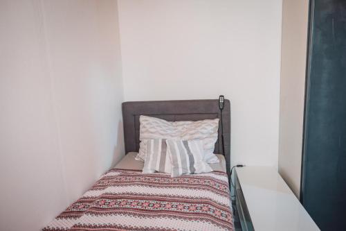 a small bed with a blanket and pillows on it at Bungalow Donaublick mit Pool und Garten in Sankt Nikola an der Donau