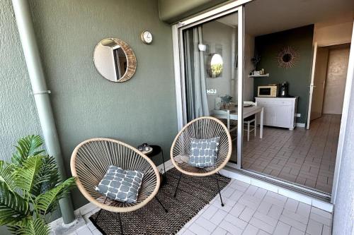 - 2 fauteuils en osier avec oreillers installés sur une terrasse couverte dans l'établissement 044 - L' Equateur Studio Cabine 4pers - 150m Plage, à La Grande Motte