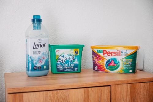 a bottle of water and two cans of milk on a wooden shelf at Bungalow Donaublick mit Pool und Garten in Sankt Nikola an der Donau