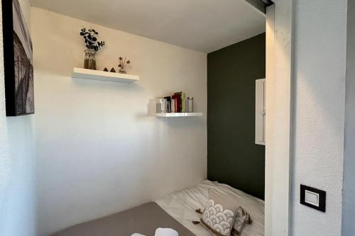 Cette petite chambre comprend un lit et un mur vert. dans l'établissement 044 - L' Equateur Studio Cabine 4pers - 150m Plage, à La Grande Motte