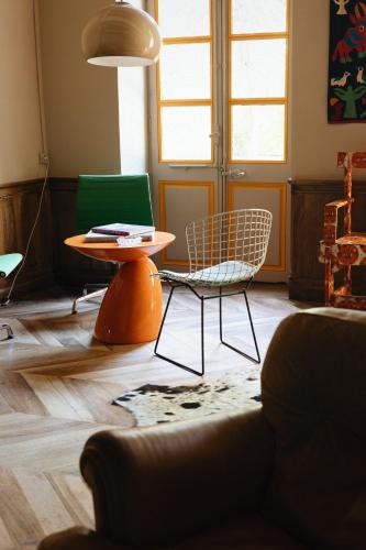 a living room with a chair and a table at La maison odette in Aulas