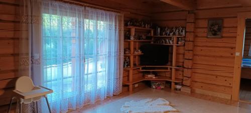 a room with a large window and a television at Góralski Domek Na Skarpie in Piwniczna Zdrój