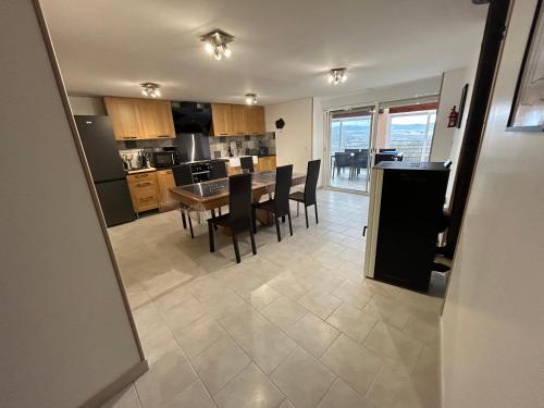 une cuisine et une salle à manger avec une table et des chaises dans l'établissement Le domaine du bez gite de Jules piscine,sauna,sauna,hammam,spa, à Saint-Laurent-dʼOlt