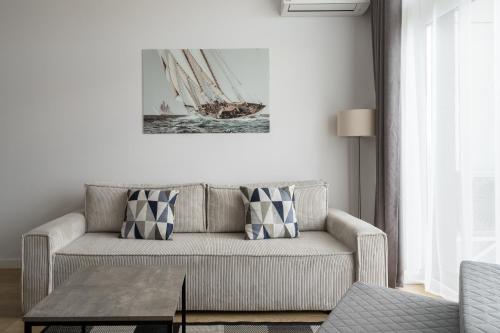 a living room with a couch and a boat on the wall at RentPlanet - Apartamenty Zarembowicza in Wrocław
