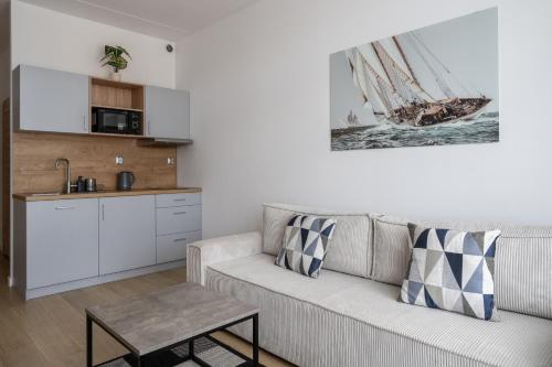 a living room with a couch and a kitchen at RentPlanet - Apartamenty Zarembowicza in Wrocław
