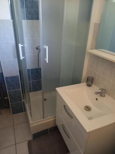 une salle de bain avec un lavabo et une douche dans l'établissement Studio village de vacances, à Arles