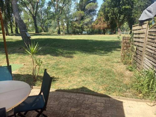 une terrasse avec une table et des chaises dans un parc dans l'établissement Studio village de vacances, à Arles