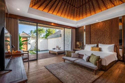 a bedroom with a bed and a couch at Nirwana Beach & Resort in Candidasa