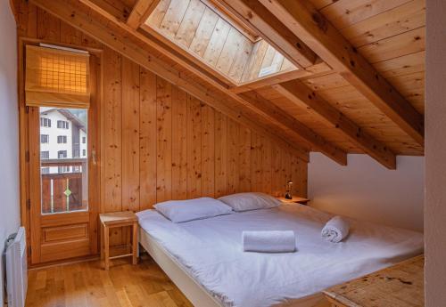une chambre avec un grand lit avec un plafond en bois dans l'établissement Apartment Capucin - A 3 Bedroom Chamonix Mountain Loft, à Chamonix-Mont-Blanc