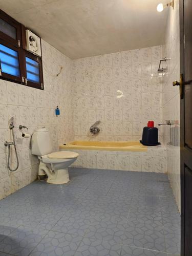 a bathroom with a toilet and a bath tub at God's Own country Kovalam By Bestinn Leisure in Vilinjam