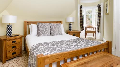 a bedroom with a bed and a chair at Lodges by Atholl Palace in Pitlochry