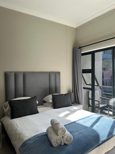 a bedroom with a large bed with towels on it at Meridian Suite Apartments in Umhlanga Ridge in Durban