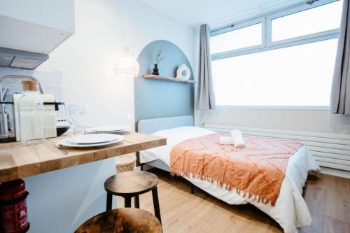 Un dormitorio con una cama y un escritorio y una ventana. en Sweet Love Room - Jacuzzi Privatif, en Montreuil