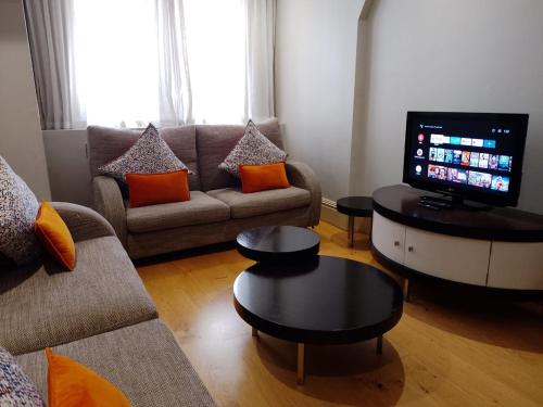 a living room with a couch and a tv at Mandela Rhodes Place in Cape Town