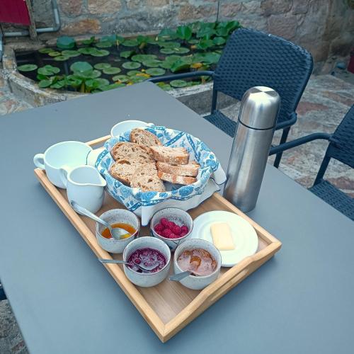 een dienblad met brood en andere voedingsmiddelen op een tafel bij Aqua Terra Silva in Gravières