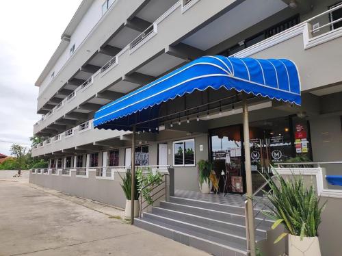 a building with a blue umbrella in front of it at Hotel M Rojana Ayutthaya in Ban Sang