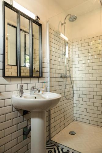 une salle de bain blanche avec un lavabo et une douche dans l'établissement La Jolie Longère Fleurie Tiny house avec piscine et jardin, à Le Gué-dʼAlléré