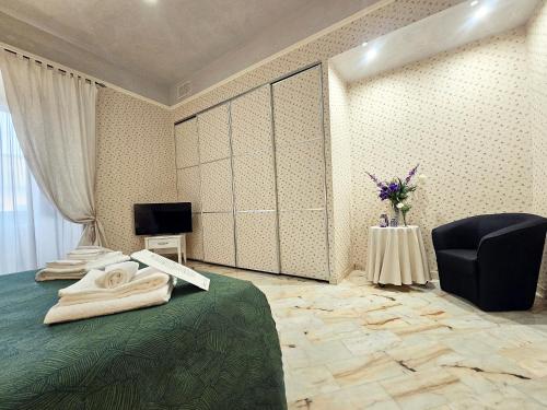 a bedroom with a bed and a chair and a television at Domus Clara - guest house Venosa in Venosa