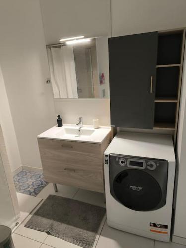 une petite cuisine avec un évier et un micro-ondes dans l'établissement Appartement de 40 m2 ensoleillé et paisible, à Franconville