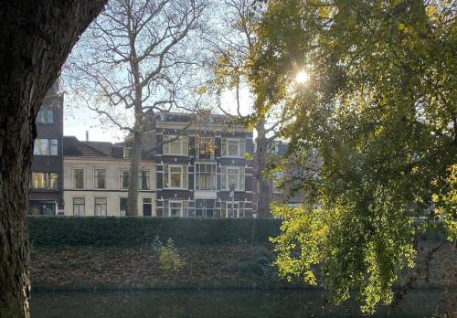 a large building in the middle of a park with trees at Suite Canalhouse Majestic in Utrecht