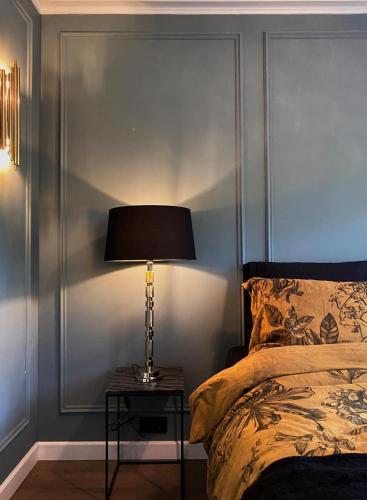 a bedroom with a bed and a lamp on a table at Suite Canalhouse Majestic in Utrecht