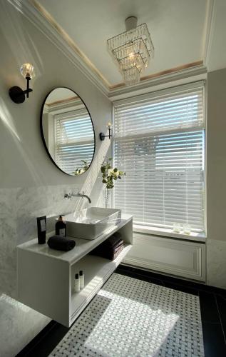 a bathroom with a sink and a mirror at Suite Canalhouse Majestic in Utrecht