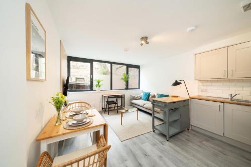 a kitchen and a living room with a table at Castle Street Apartment in Dundee