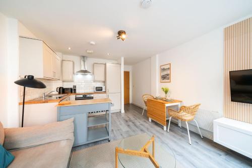 a kitchen and living room with a couch and a table at Castle Street Apartment in Dundee