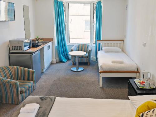 a room with a bedroom with a bed and a table at Reef Lodge in Newquay