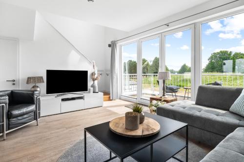 a living room with a couch and a tv at Ferienwohnung Große Freiheit Olpenitz in Olpenitz