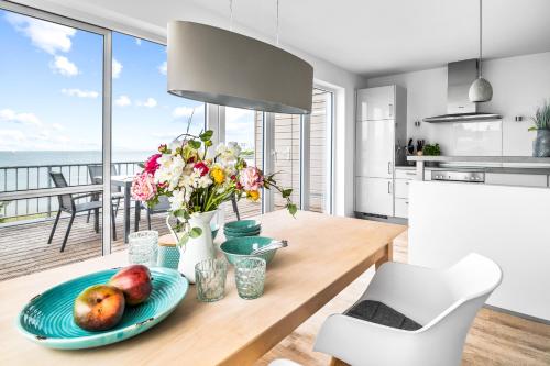 a kitchen with a table with a plate of fruit and flowers at Ferienwohnung Große Freiheit Olpenitz in Olpenitz