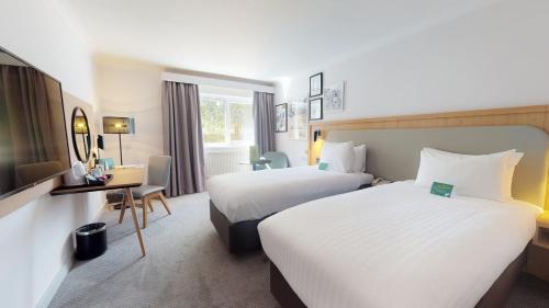 a hotel room with two beds and a television at Holiday Inn Cambridge by IHG in Cambridge