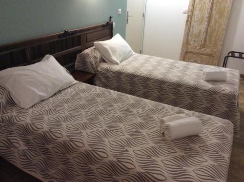 two beds sitting next to each other in a room at Hotel Restaurant de la Poste in Aullène