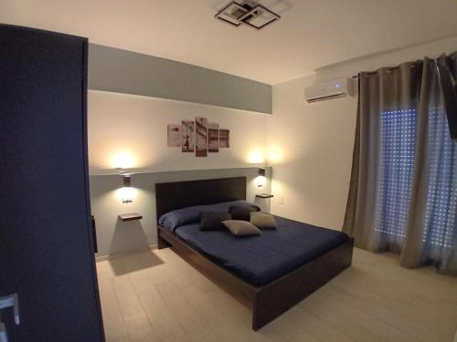 a bedroom with a blue bed with two pillows on it at Affitti brevi TAORMINA in Realmonte