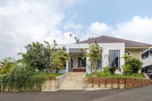 a white house with stairs and trees at Salma Syariah by TwoSpaces, Bogor in Jakarta