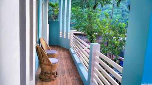 a porch with two chairs and a balcony with a view at Shatsngi Home Stay in Dawki