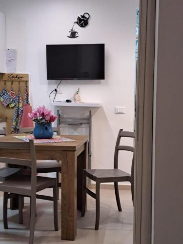 a dining room with a table and chairs and a television at Futtitinni Home casamia in Palermo